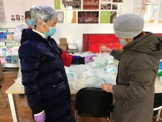 為樓棟分發(fā)口罩，并為包裝袋消毒